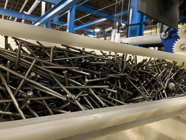 Plated metal nails in a bin